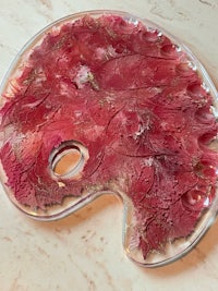 a glass palette with red paint on it