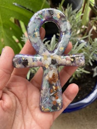 a person holding an ankh in front of a plant